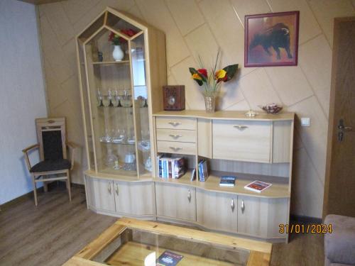 a room with a cabinet with a mirror and a table at Ferienwohnung Janne in Fürstenberg