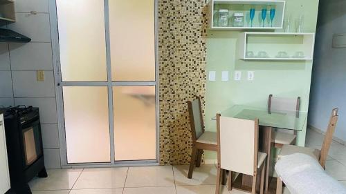 eine Küche mit einem Tisch und einer Glastür in der Unterkunft Casa de Esquina, em Avenida Principal in Três Lagoas