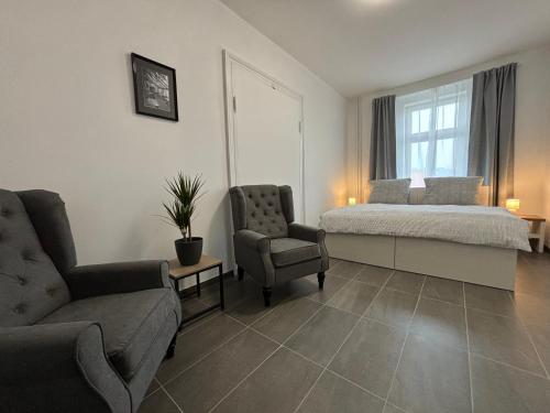 a bedroom with a bed and a couch and a chair at Apartmány Plzeň Rolnické náměstí 8 in Plzeň