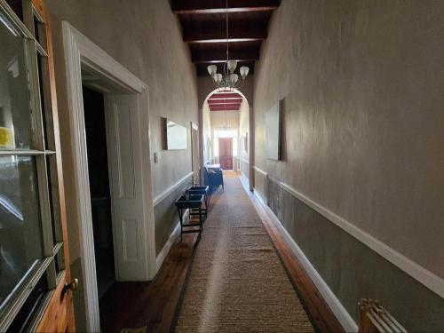 an empty hallway with blue chairs in a building at Magoos on 62 in Ladismith