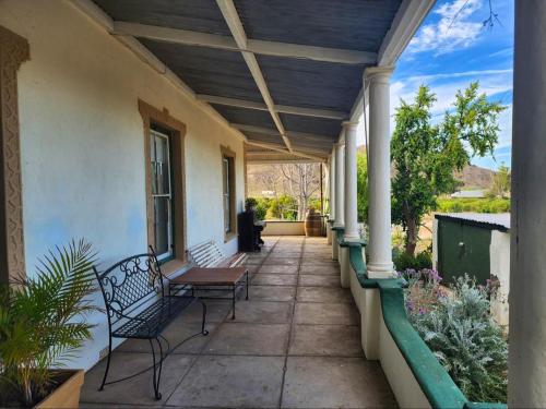 a porch of a house with two benches on it at Magoos on 62 in Ladismith