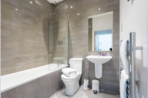 a bathroom with a toilet and a sink and a shower at Belfry Quarters Redhill in Redhill