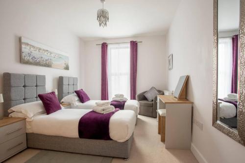 um quarto com uma cama grande e um espelho em Belfry Quarters Redhill em Redhill