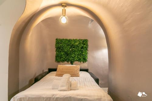 Cette chambre dispose d'un lit avec une plante sur le mur. dans l'établissement MBA Splendide Appart - Proche du Moulin Rouge, à Paris