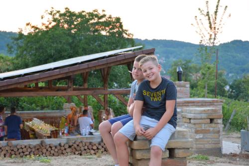 two young boys sitting on a stone bench at Vass-Villa Vendégház in Szekszárd