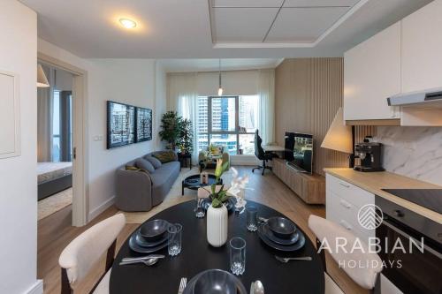 a kitchen and a living room with a table and chairs at Exclusive Newly Renovated 1BR full Marina views in Dubai