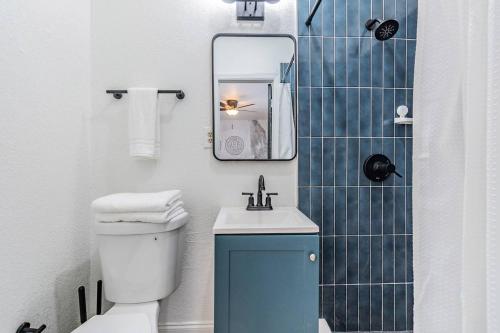 een badkamer met een toilet, een wastafel en een spiegel bij Satoshi Hideout Living - Rooms & Studios in St Petersburg