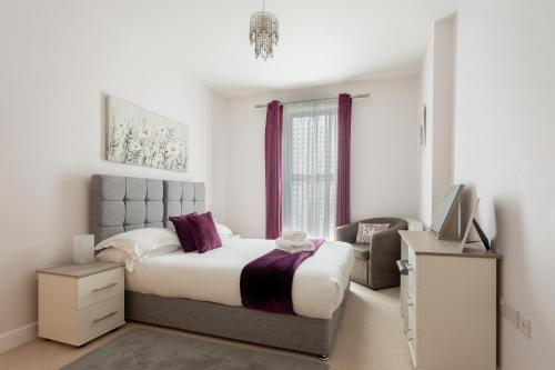 um quarto com uma cama grande e uma cadeira em Queens Lodge 1-Bed Apartment in Redhill em Redhill