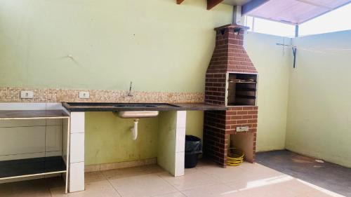 uma cozinha com um lavatório e um forno de tijolo em Casa de Esquina, em Avenida Principal em Três Lagoas