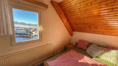 a small room with a bed and a window at Apartmány chata Samoty in Železná Ruda