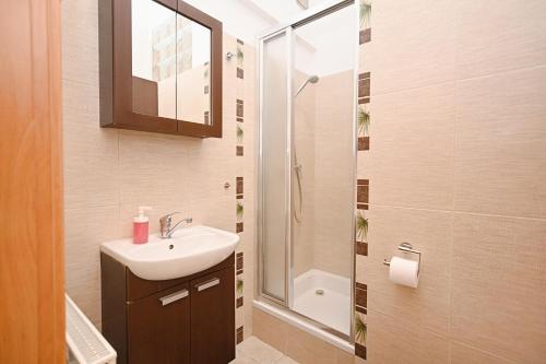 une salle de bain avec lavabo et douche dans l'établissement Victus Apartamenty, Apartament Tuż Przy Plaży, à Sopot