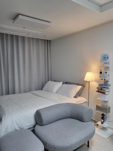 a bedroom with a large bed and a chair at feel at home in Daegu