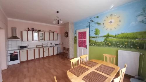 kuchnia ze stołem i zegarem na ścianie w obiekcie Apartman pod Zamkem w Javorníku