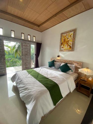 a bedroom with a large bed and a large window at Umah Saren Homestay in Undisan