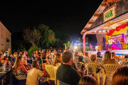 een menigte mensen die in stoelen zitten te kijken naar een concert bij Camping Vendres in Vendres