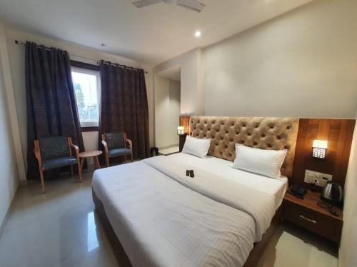 a bedroom with a large white bed in a room at HOTEL SCARLET in Gwalior