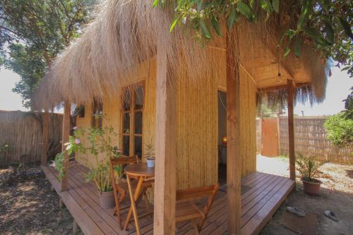 a small wooden hut with a table and a straw roof at El Arbol Eco Lodge in La Serena