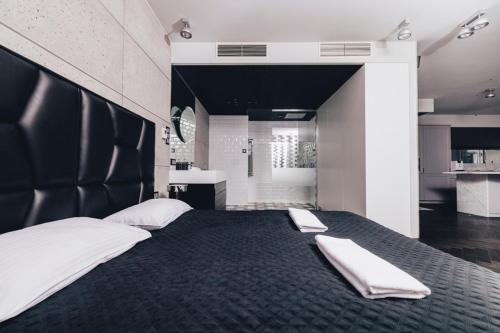 a bedroom with a large bed with two white towels on it at Black Pearl - Amazing City View, 130 sqm in Warsaw