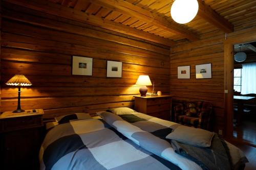 una camera da letto con letto in una camera in legno di Lakeside Rustic Luxury a Kajaani