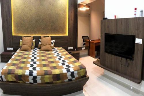 a bedroom with a bed and a flat screen tv at D Villa : A posh bunglow with modern amenities in Panaji