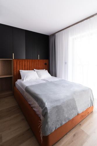 a bedroom with a large bed with a large window at Alpina Residence & Kameralne SPA in Bukowina Tatrzańska