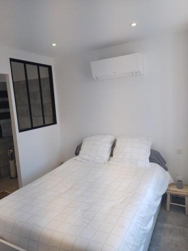 - un grand lit blanc dans une chambre blanche dans l'établissement Le Clos Fontaine, à Grasse