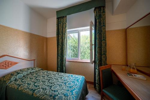 a bedroom with a bed and a window at Hotel Mary in Vicenza