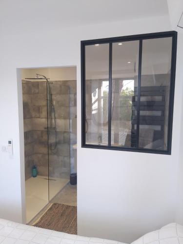La salle de bains est pourvue d'une douche en verre avec une porte en verre. dans l'établissement Le Clos Fontaine, à Grasse