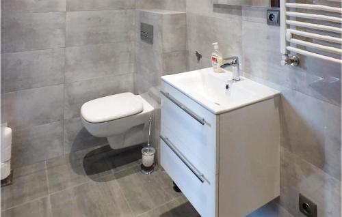 a bathroom with a white toilet and a sink at Amazing Home In Mielno With Kitchen in Mielno