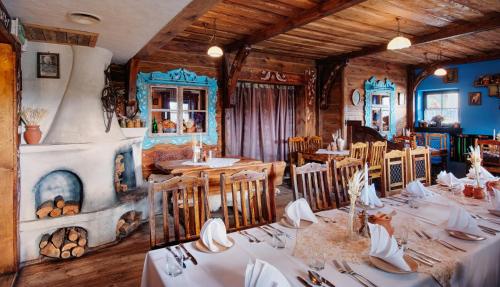 une salle à manger avec des tables, des chaises et une cheminée dans l'établissement Gościniec Oycowizna, à Lesznowola