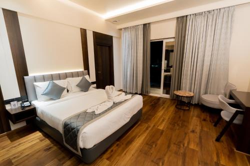 Habitación de hotel con cama y escritorio en Hotel Le Grandeur, en Narasimharaja Puram