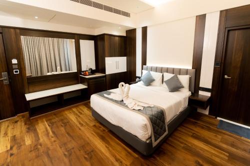 1 dormitorio con 1 cama y suelo de madera en Hotel Le Grandeur en Narasimharaja Puram