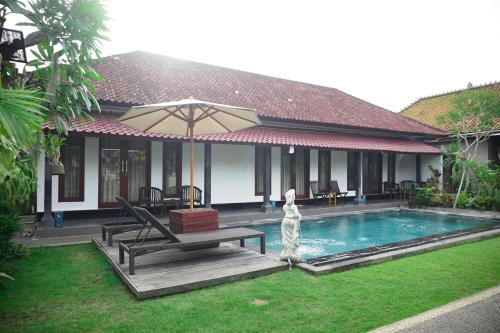 une maison avec une piscine entourée d'un parasol dans l'établissement Kim Homestay, à Ubud