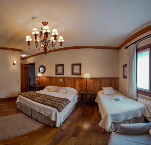 Cette chambre comprend deux lits et un lustre. dans l'établissement Hotel Solar d'Izabel, à Campos do Jordão