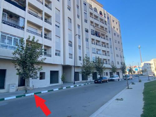 a red arrow is pointing to a building at Appart Neuf Lumineux Climatisé 1ère étage in Tangier