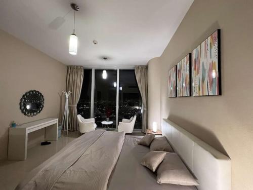 salon z dużą kanapą i dużym oknem w obiekcie شقة في برج رافال بإطلالة ساحره w Rijadzie