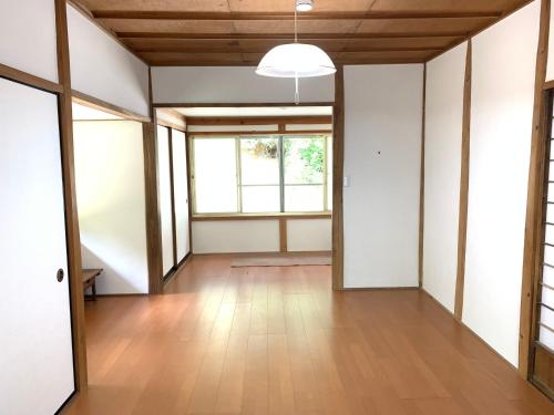 an empty room with a wooden floor and a window at あんばええ 