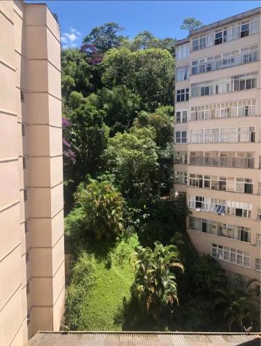 uma vista da janela de um edifício com árvores em Apartamento área nobre em Petrópolis
