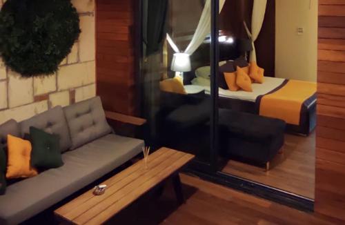 a living room with a couch and a bed at TNR Otel & Spa in Kusadası