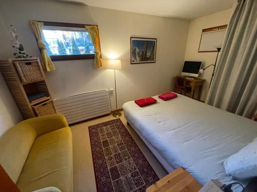 1 dormitorio con cama, sofá y ventana en Chalet Champraz - Free Parking, en Chamonix-Mont-Blanc