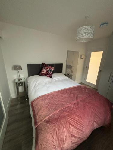 a bedroom with a large bed with a red blanket at Clifden Lodge 1 Bedroom Apt in Killarney