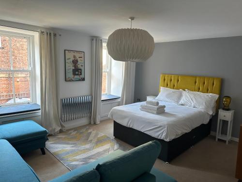 a bedroom with a bed and a couch in it at Luxury Retro 4 Bed Town House in heart of Alnwick in Alnwick