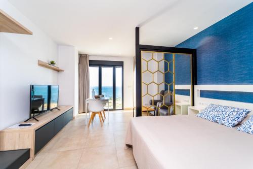 ビリャホヨサにあるLa Punta COLORS By DLVのベッドとテレビが備わるホテルルームです。