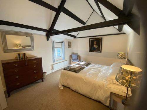 ein Schlafzimmer mit einem großen Bett und einer Kommode darin in der Unterkunft Ffawydden - a listed gem in the National Park in Abergavenny