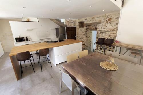 une cuisine et une salle à manger avec une table et des chaises dans l'établissement Ensemble de Maisons avec Vue sur la Nature, à Bains-sur-Oust