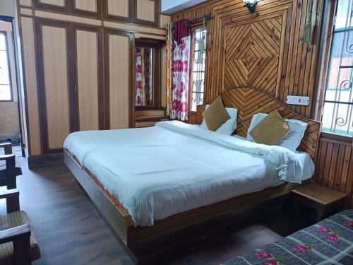 a bedroom with a large bed with a wooden headboard at zoz sm 5 in Shimla