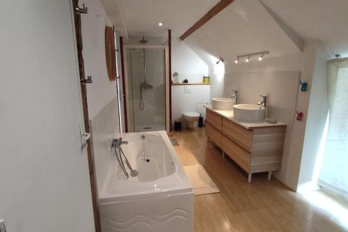 La grande salle de bains est pourvue de 2 lavabos et d'une baignoire. dans l'établissement Ensemble de Maisons avec Vue sur la Nature, à Bains-sur-Oust
