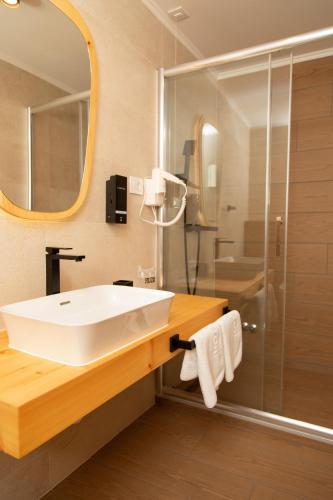 a bathroom with a white sink and a shower at Vila Ana in Kalesija