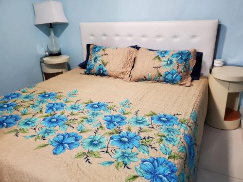 a bed with blue flowers on it in a bedroom at Chic 3 Bedroom Unit, Few Steps To The Ocean, Barbosa Unit 4 in Catano