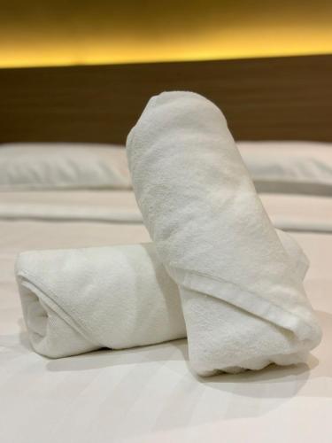 two white beds with white towels on them at STAR HOTEL in Tawau